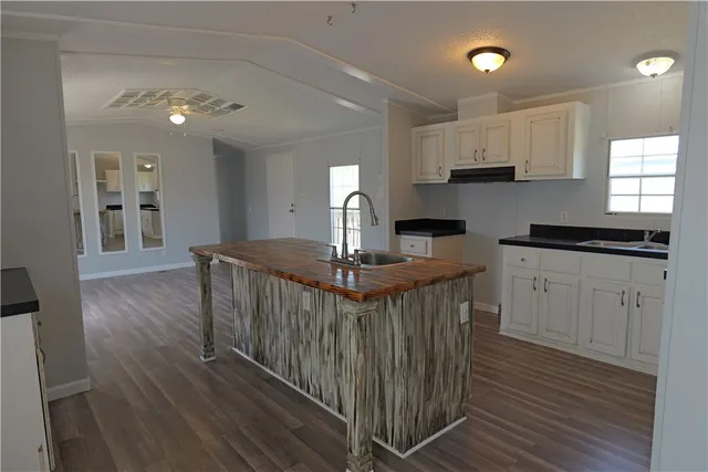 a kitchen with stainless steel appliances granite countertop a stove a sink dishwasher and a refrigerator with wooden floor