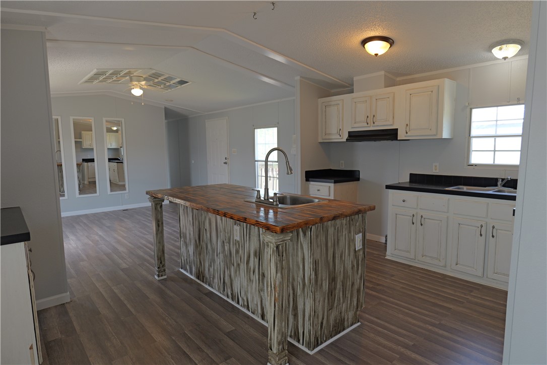 a kitchen with stainless steel appliances granite countertop a stove a sink dishwasher and a refrigerator with wooden floor