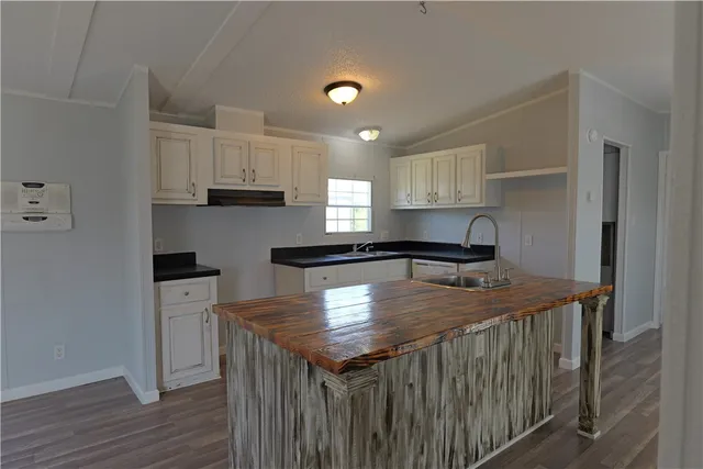 a kitchen with stainless steel appliances granite countertop a kitchen island a stove a refrigerator a sink and a cabinets