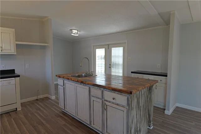 a kitchen with granite countertop white cabinets and wooden floor