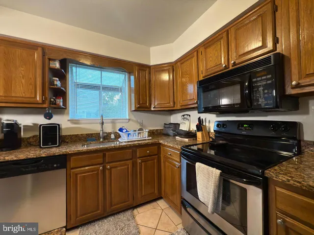 a kitchen with stainless steel appliances granite countertop a stove microwave and sink