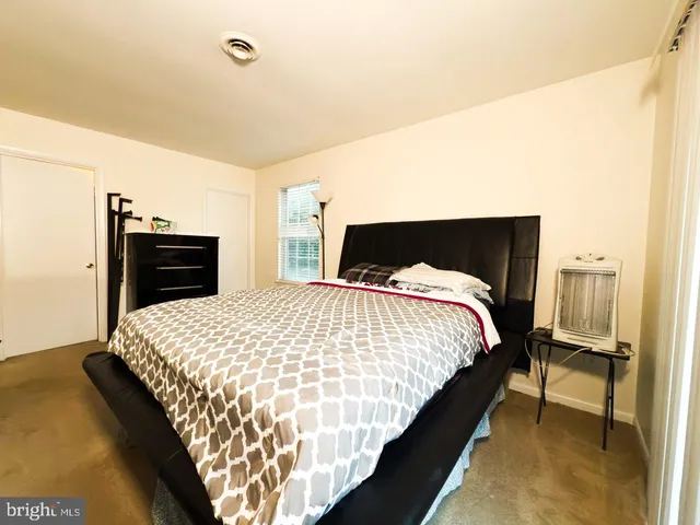 a bed sitting in a bedroom with a bed and dresser