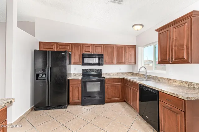 a kitchen with stainless steel appliances granite countertop a refrigerator and a sink