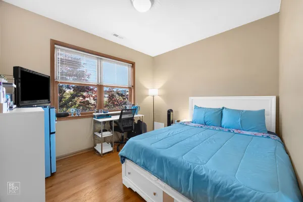 a bedroom with a large window and a flat screen tv