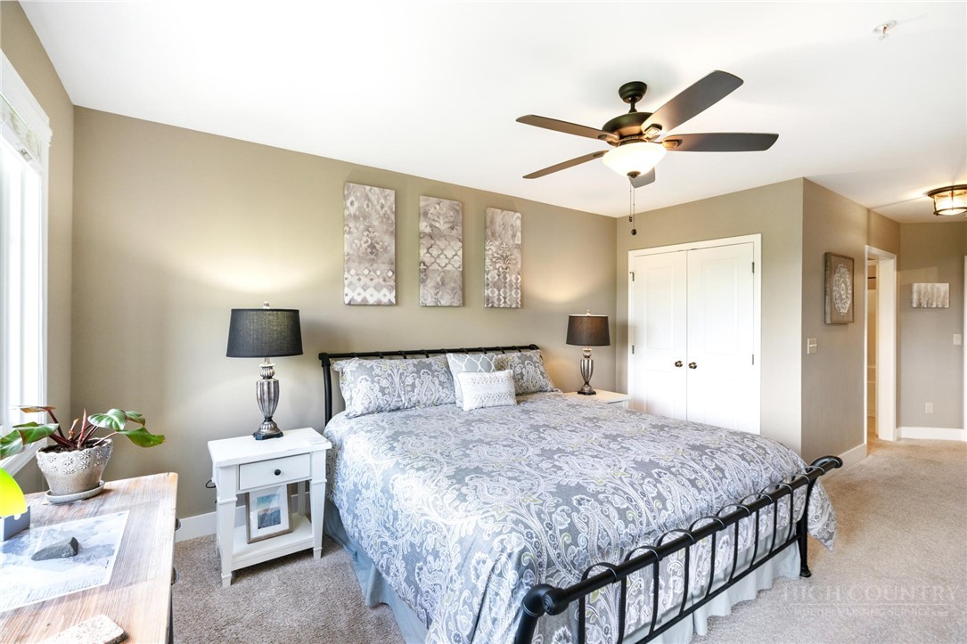 942 Ridge Haven Parkway, Unit R1211 Banner Elk, NC 28604 - Photo 23 of 45 a bedroom with a bed and a chandelier