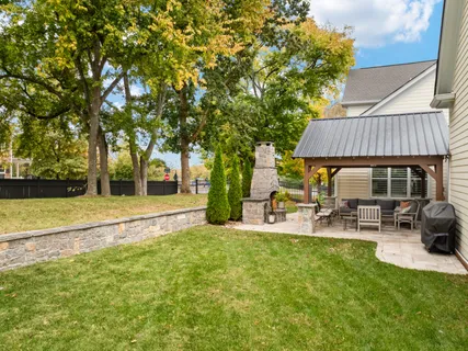a view of house with backyard and outdoor seating