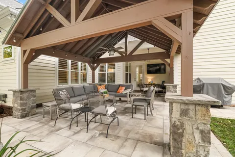 a view of a white house with a yard and potted plants