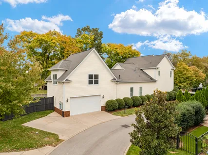 a view of house with a yard and a large tree