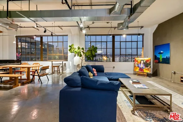 a living room with furniture kitchen view and a large window
