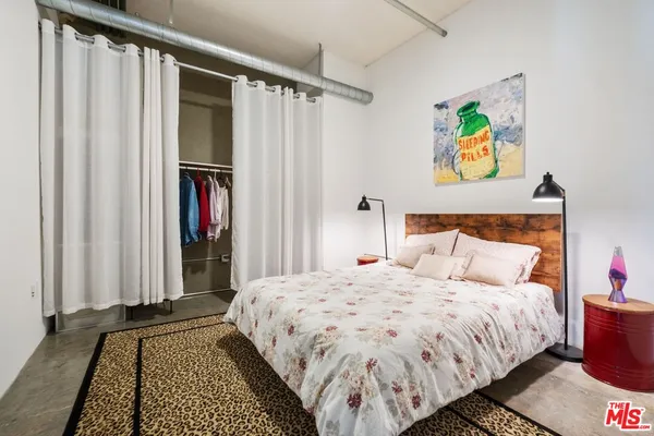a bedroom with a bed and a painting on the wall