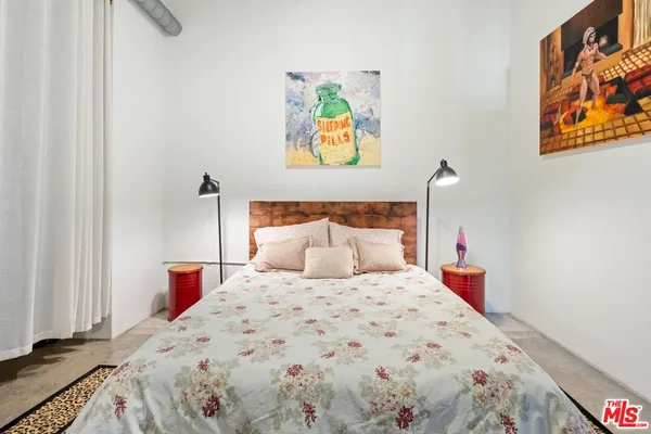 a bedroom with a bed and a painting on the wall