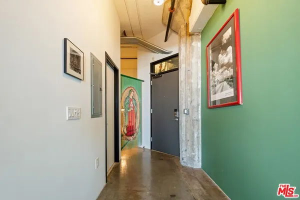 a view of hallway with furniture and a chandelier