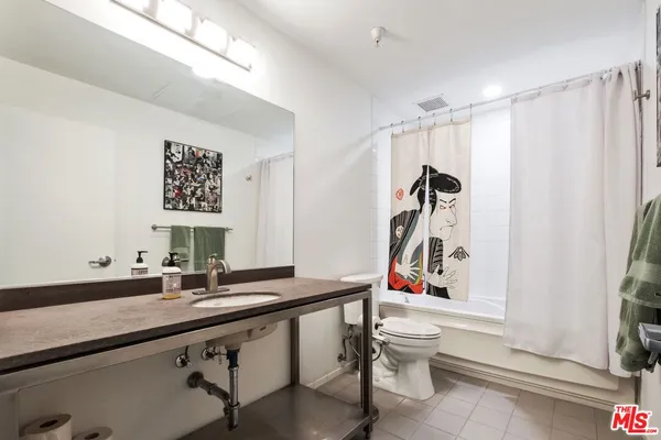 a bathroom with a granite countertop sink and a bathtub