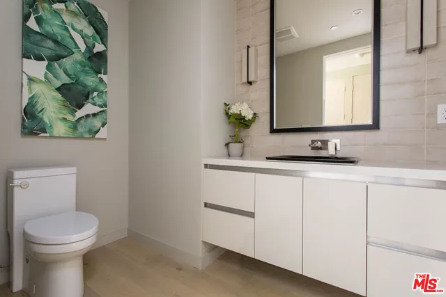 a bathroom with a toilet a sink and mirror