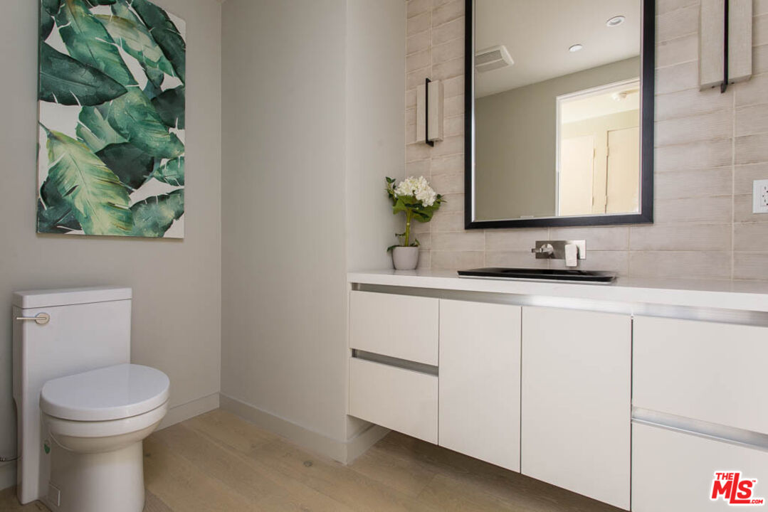 1621 Malcolm Avenue, Unit 101 Los Angeles, CA 90024 - Photo 14 of 34 a bathroom with a toilet a sink and mirror