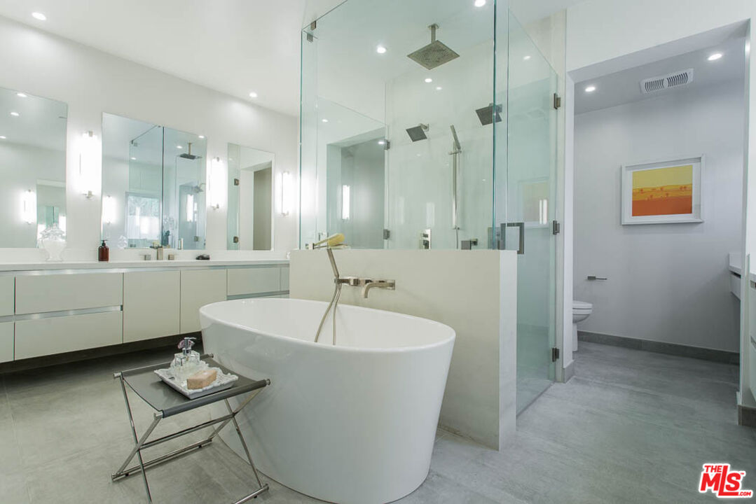 1621 Malcolm Avenue, Unit 101 Los Angeles, CA 90024 - Photo 19 of 34 a bathroom with a tub a sink a mirror and a shower