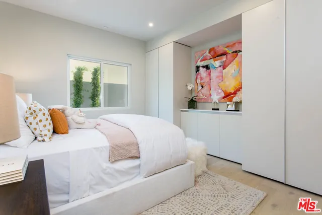 a bedroom with a bed and a painting on the wall