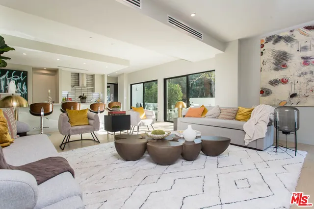 a living room with furniture potted plant and large windows