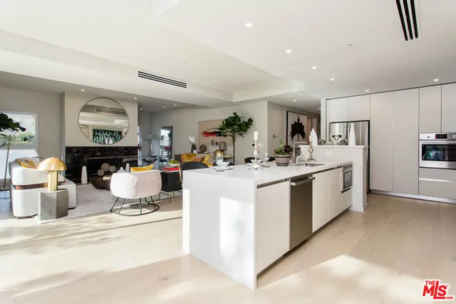 a large white kitchen with stainless steel appliances granite countertop a stove and a cabinets