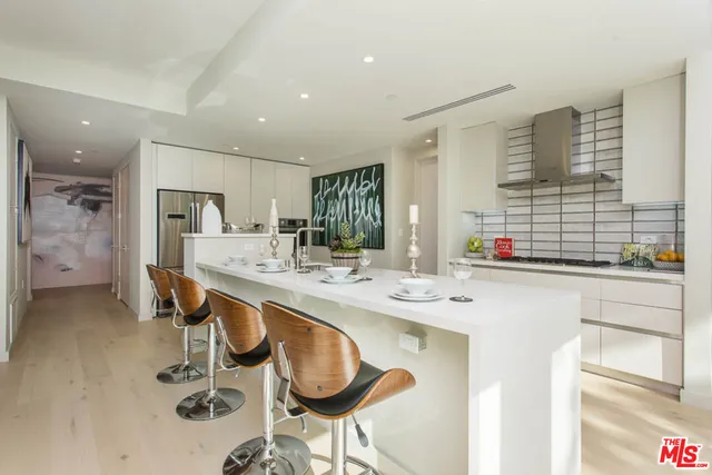 a kitchen with kitchen island granite countertop a sink and a refrigerator