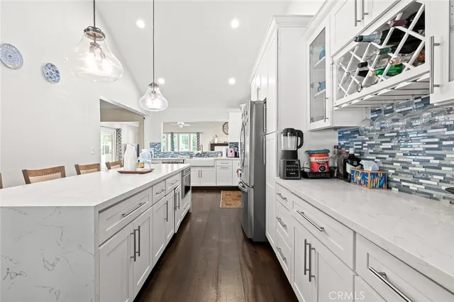 a kitchen with a refrigerator a stove a sink and dishwasher with wooden floor