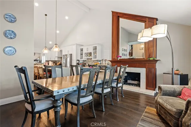 a kitchen with refrigerator a stove a dining table and chairs with wooden floor