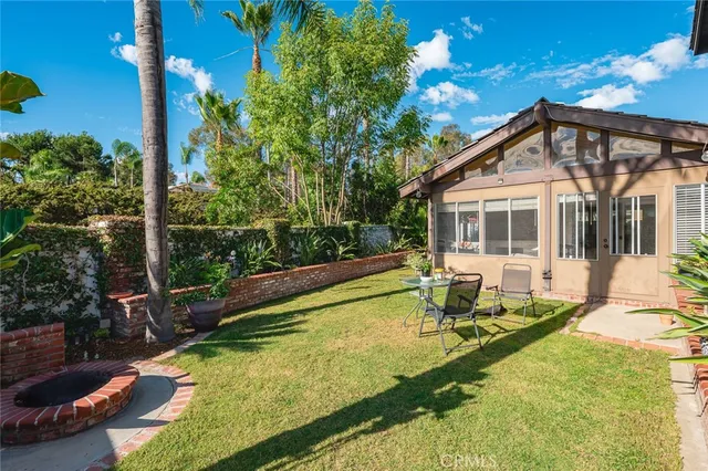 a view of a house with wooden fence and floor to ceiling window and tree