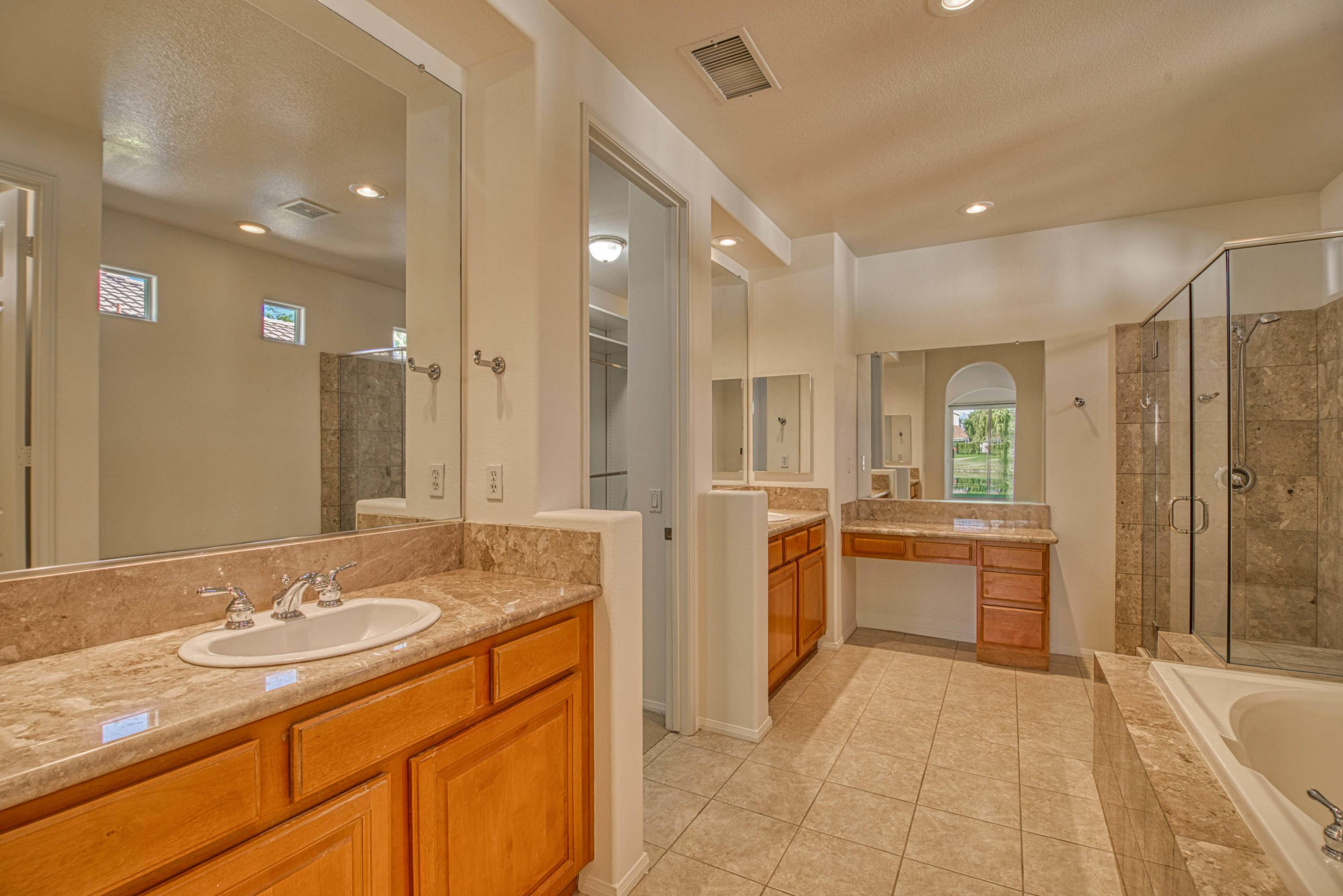 13 Wimbledon Circle Rancho Mirage, CA 92270 - Photo 42 of 62 a bathroom with a granite countertop sink mirror and bathtub