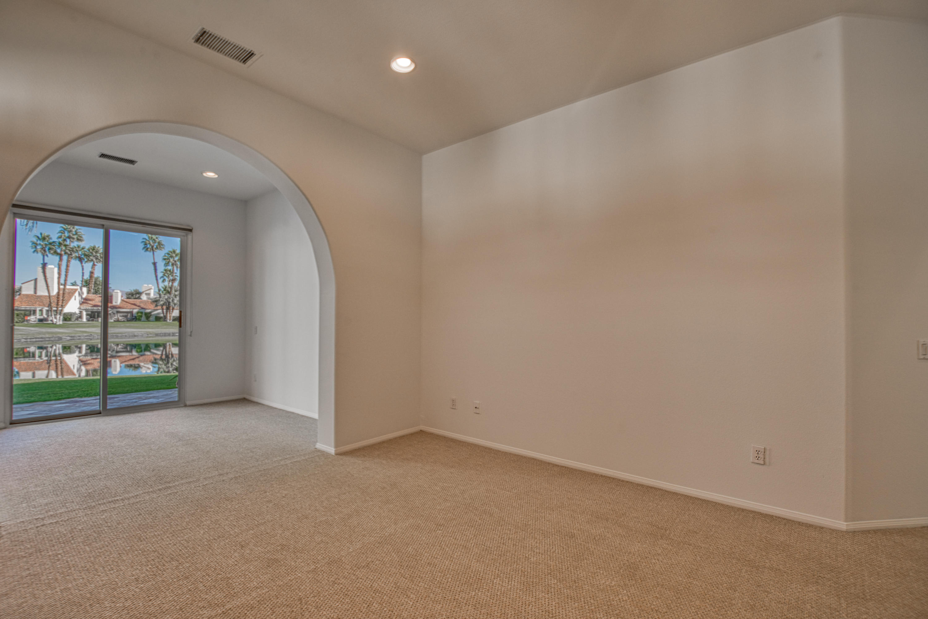 13 Wimbledon Circle Rancho Mirage, CA 92270 - Photo 46 of 62 an empty room with sliding door and wooden floor