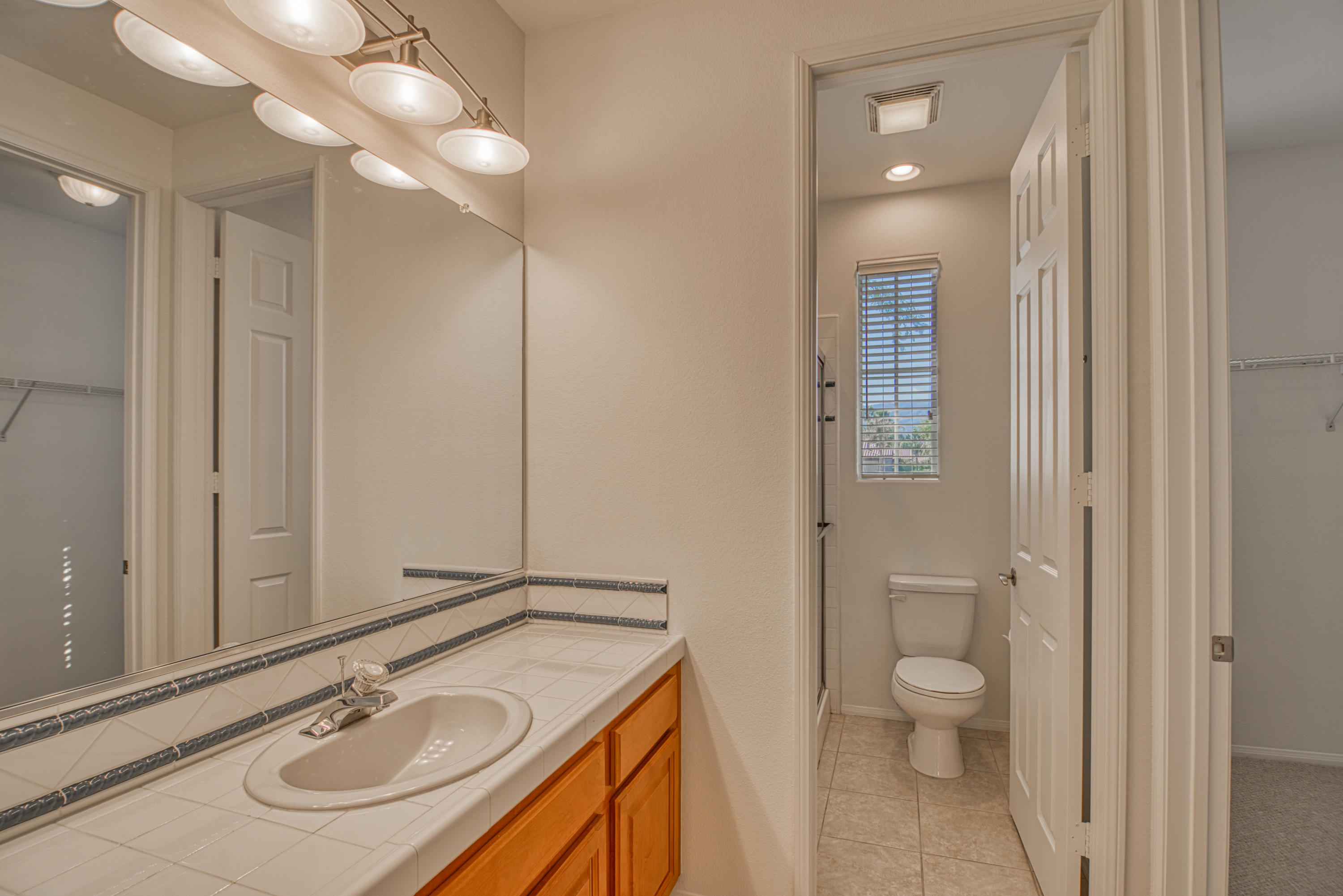 13 Wimbledon Circle Rancho Mirage, CA 92270 - Photo 49 of 62 a bathroom with a sink a toilet and a mirror