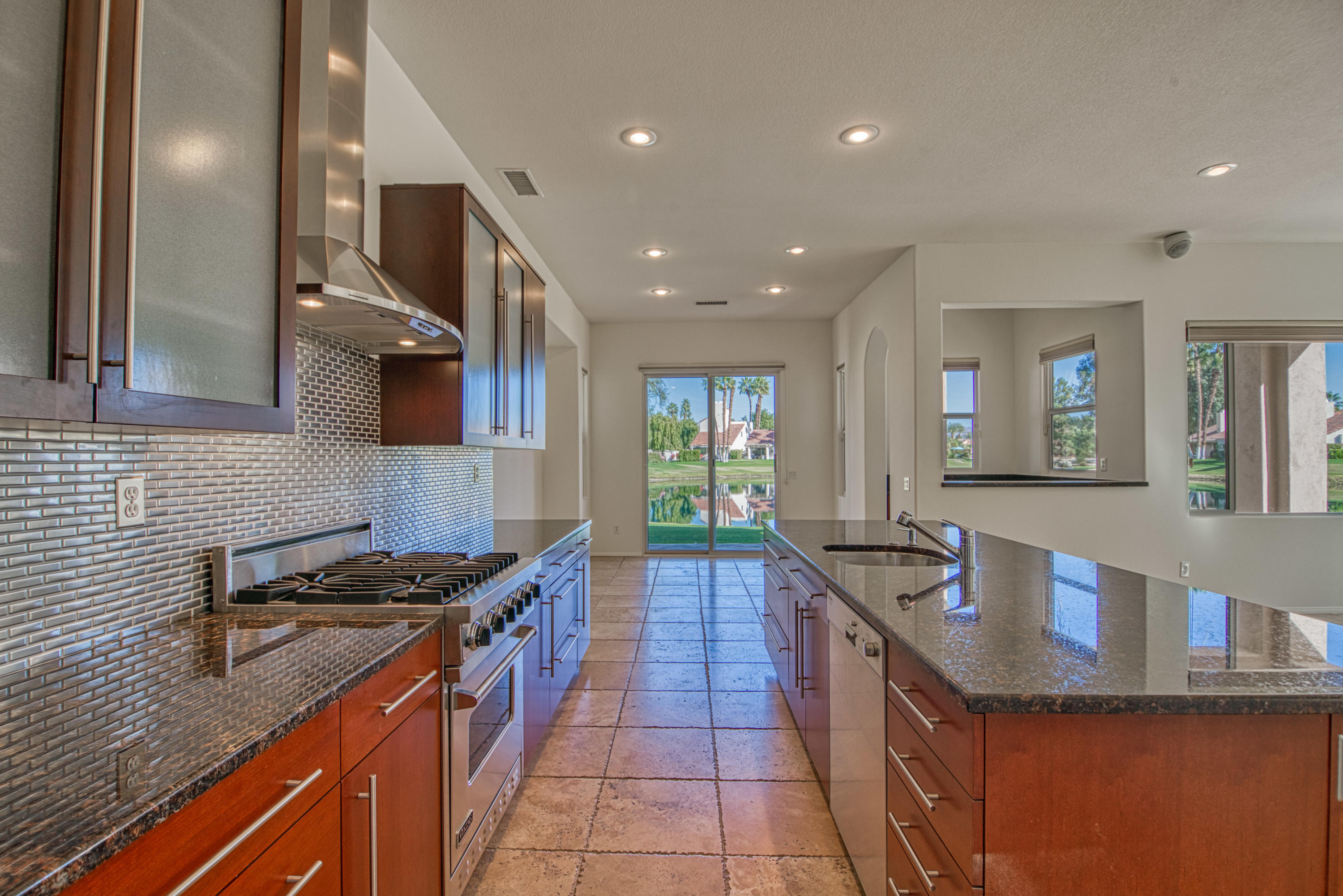 13 Wimbledon Circle Rancho Mirage, CA 92270 - Photo 56 of 62 a kitchen with stainless steel appliances granite countertop a sink stove and cabinets