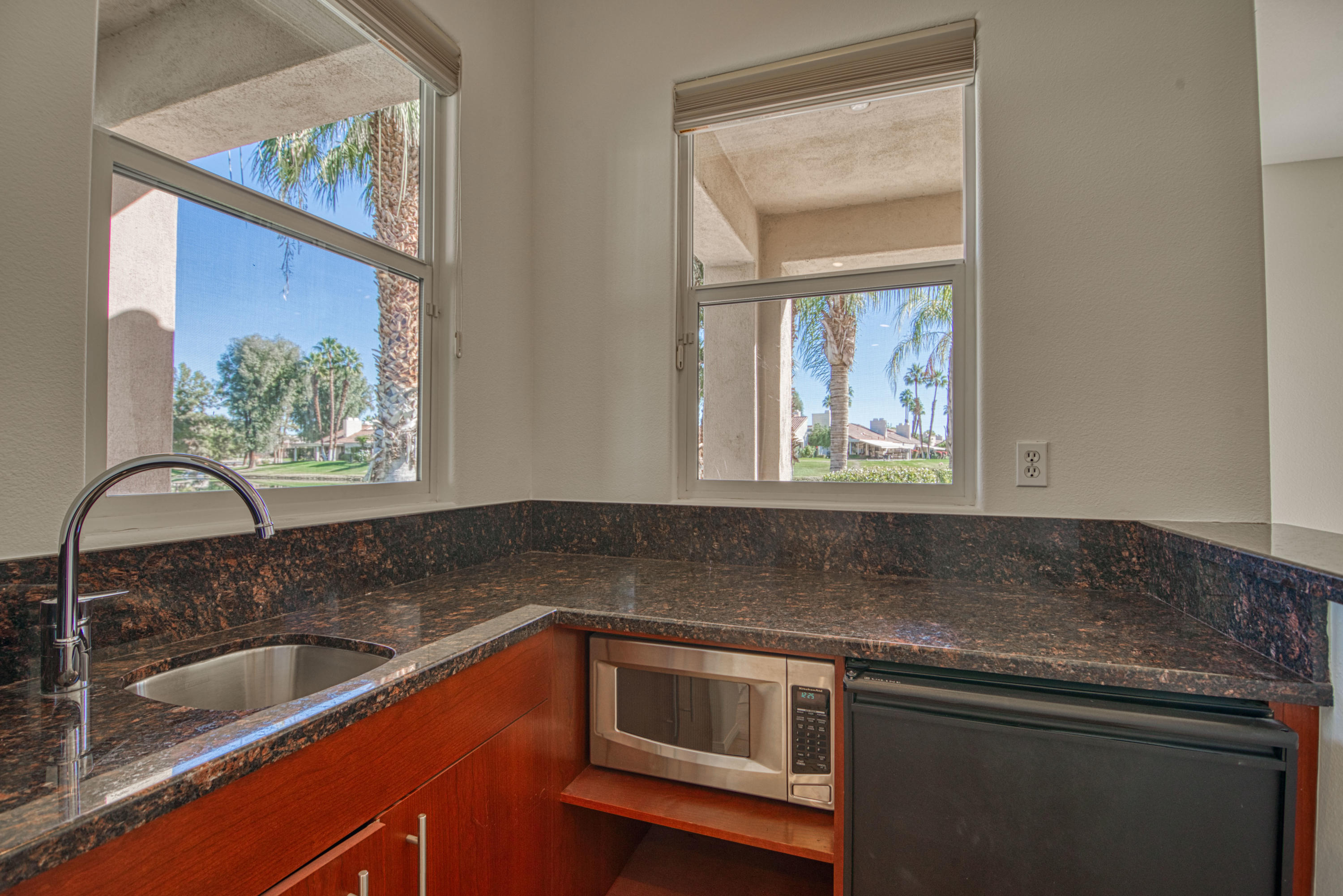 13 Wimbledon Circle Rancho Mirage, CA 92270 - Photo 60 of 62 a kitchen with granite countertop a sink and a window
