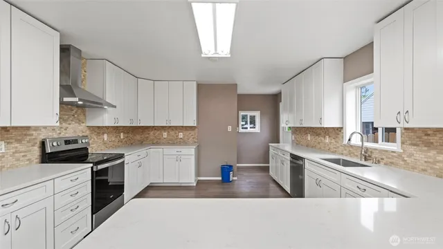 a kitchen with granite countertop a sink stainless steel appliances and cabinets