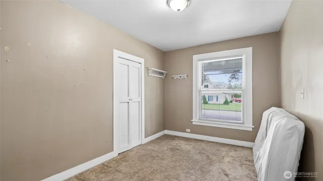 an empty room with windows and closet