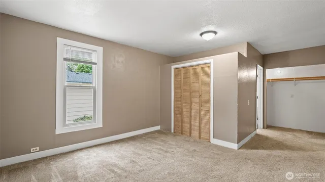 an empty room with windows and closet