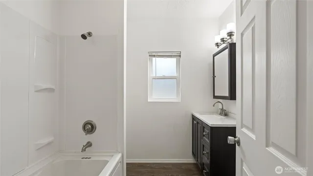 a bathroom with a tub sink a mirror and a shower