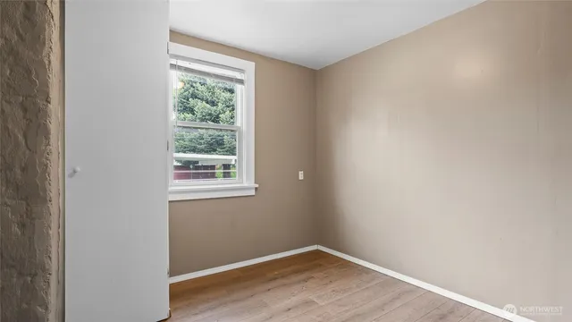 a view of a small space with wooden floor and a window