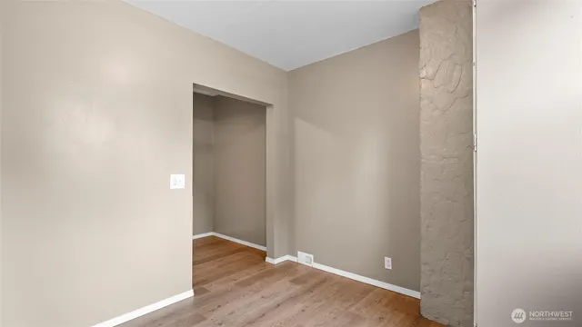 a view of an empty room with wooden floor
