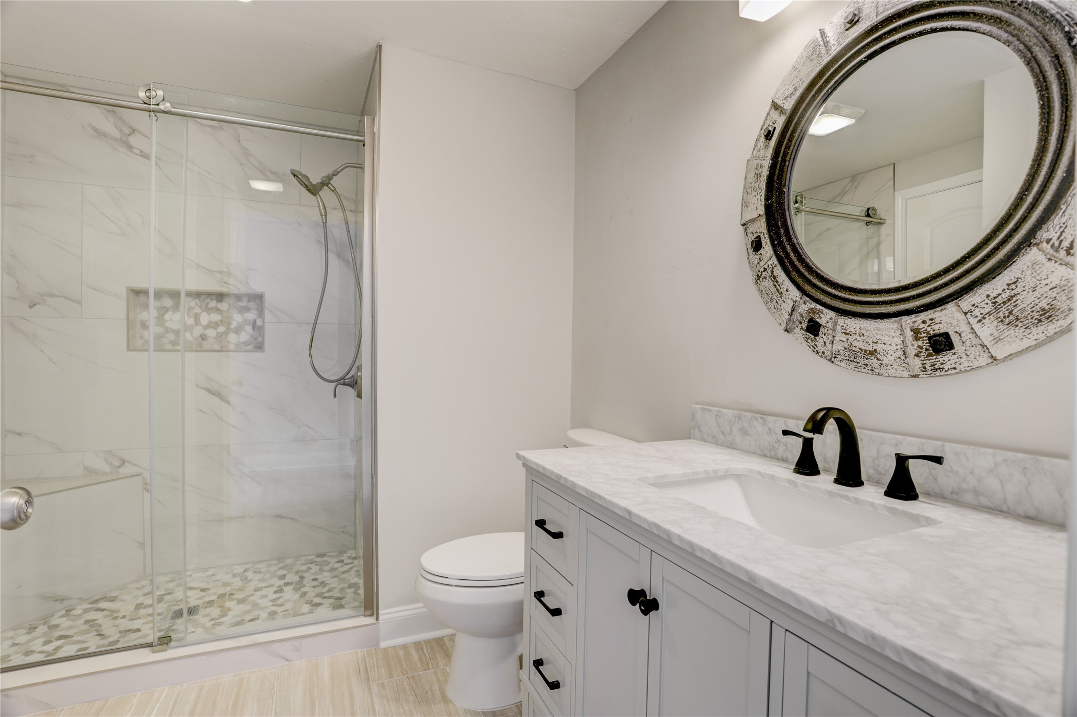 351 Lakeside Lane, Unit 102 Houston, TX 77058 - Photo 10 of 14 a bathroom with a sink a toilet and a mirror