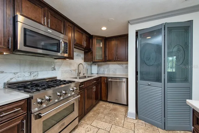 a kitchen with stainless steel appliances granite countertop a stove microwave and cabinets