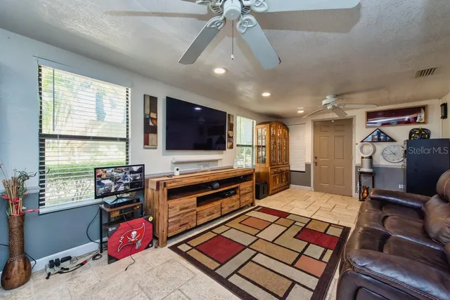 a living room with furniture a flat screen tv and a window