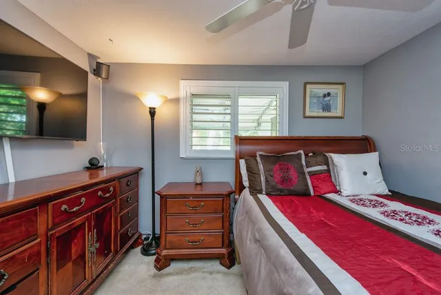 a bedroom with a bed and a tv on dresser