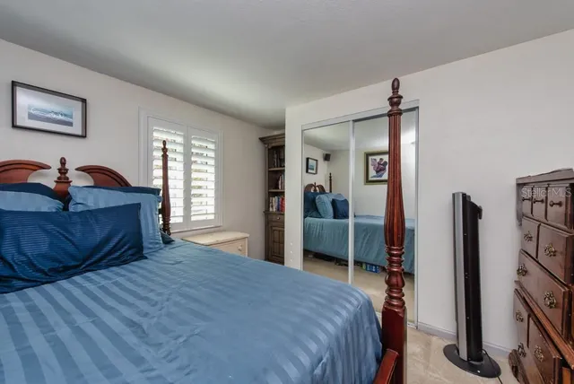a bedroom with a large bed and a flat tv screen on dresser