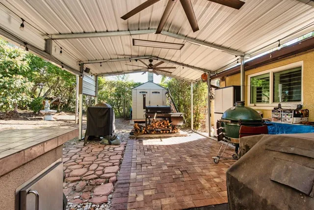 a view of a patio with table and chairs a barbeque with wooden floor and roof