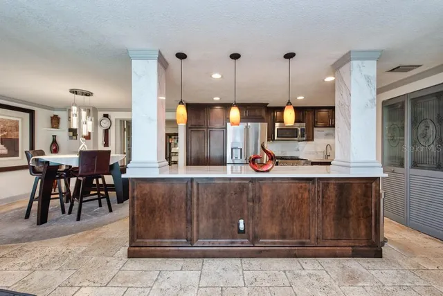 a kitchen with kitchen island granite countertop a table and chairs in it
