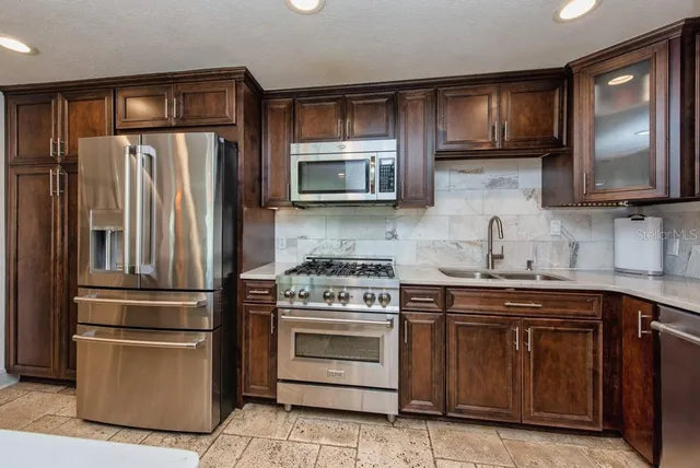 a kitchen with granite countertop stainless steel appliances and wooden cabinets