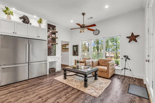 a living room with furniture a ceiling fan and a window