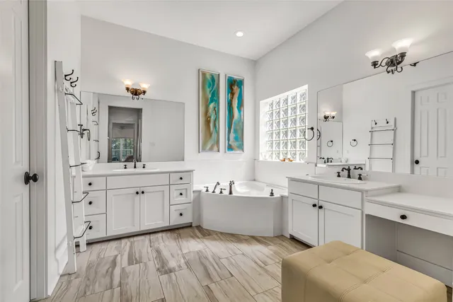 a spacious bathroom with a double vanity sink a mirror and a bathtub