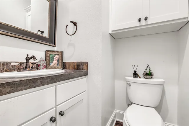 a bathroom with a toilet a sink and mirror