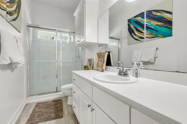 a bathroom with a sink a toilet and shower